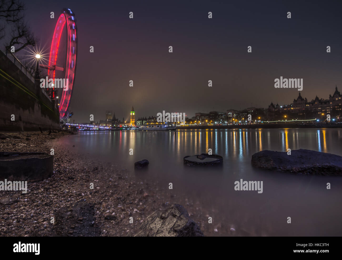 Londoner Stadtbild bei Nacht von Thames Strand bei Ebbe Stockfoto