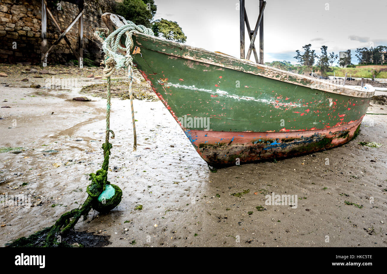 Altes Fischerboot liegt am Strand bei Ebbe in Santa Cruz Island, Oleiros, Rias Altas, A Coruña, Spanien. Stockfoto