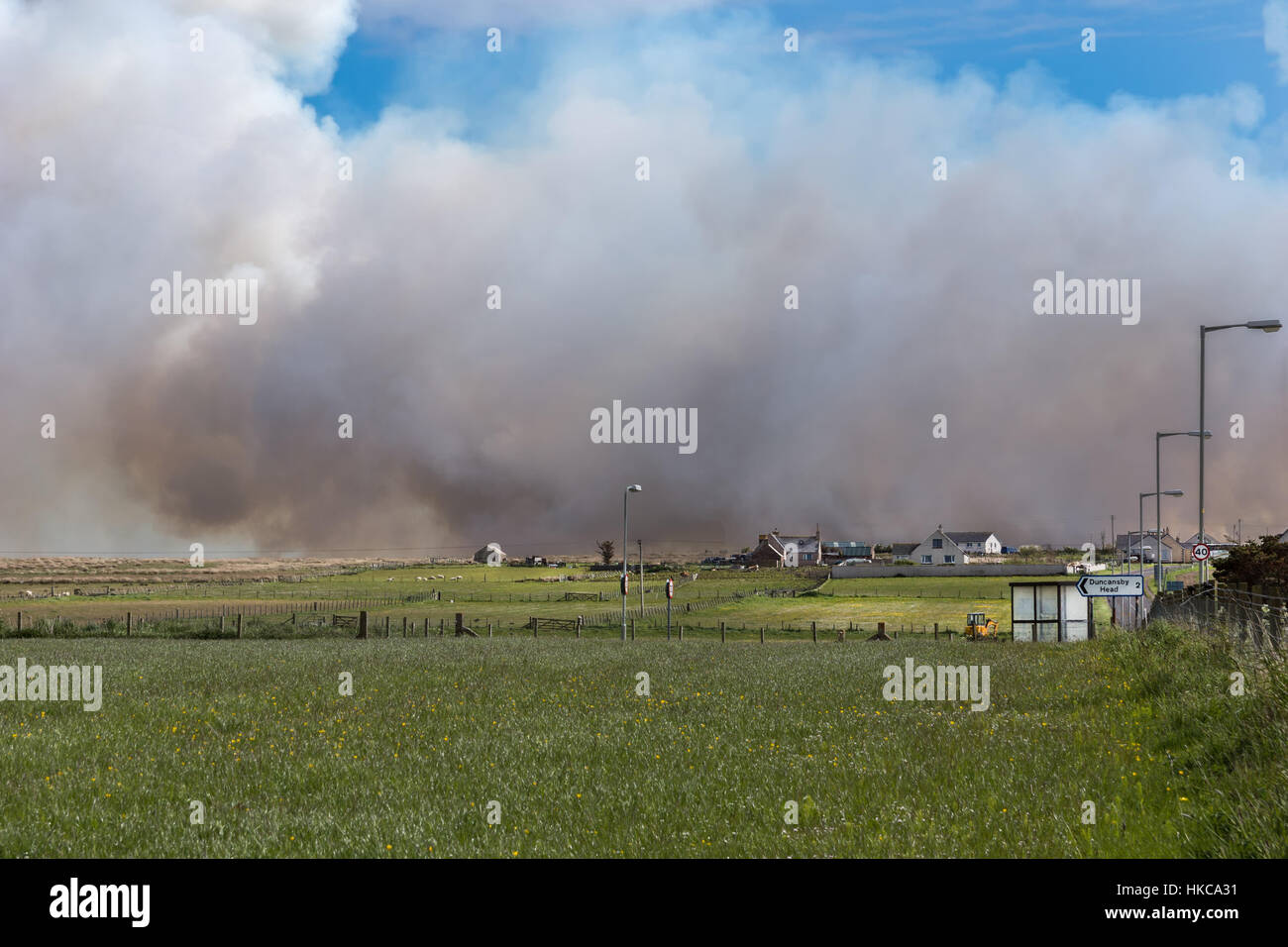 Ein Lauffeuer nähert sich Wiesen und Bauernhöfen in der Nähe von John O Groats. Stockfoto