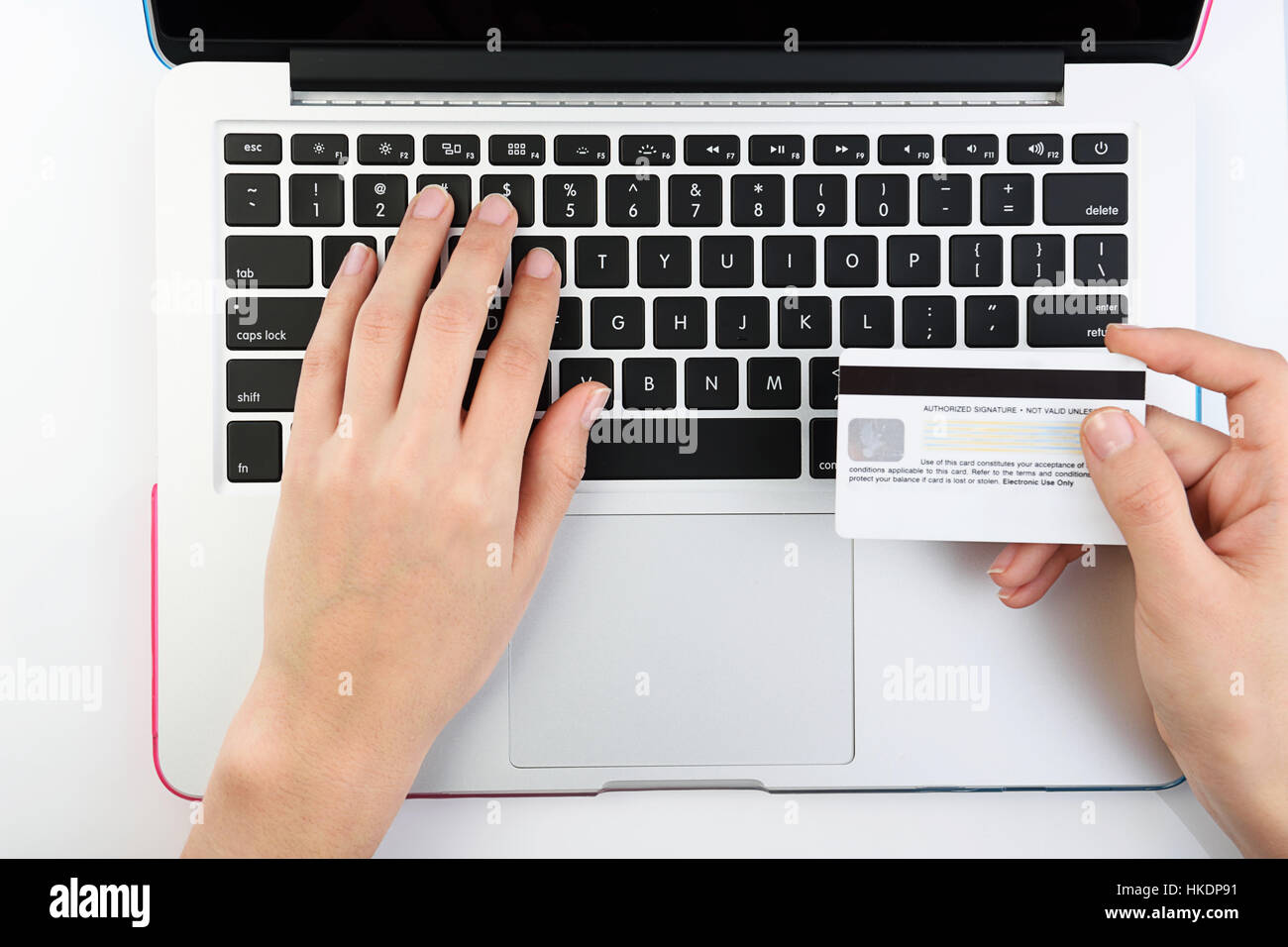 Erschossen von oben der Mensch neben Laptop mit Kreditkarte auf weißem Hintergrund Stockfoto