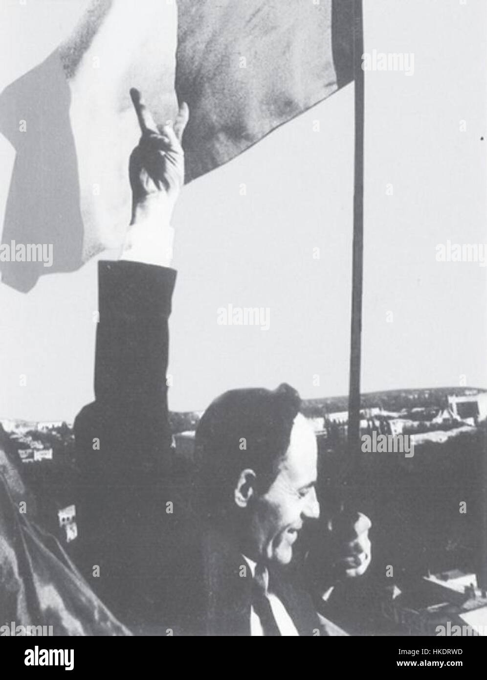 Das Kunstwerk „Arboreaza Tricolorul“ von Gheorghe Ghimpu zeigt das zeremonielle Hissen der rumänischen Flagge. Dieses Schwarzweiß-Bild fängt den Moment mit großer Symbolik ein und zeigt den nationalen Stolz und die historische Bedeutung der Tricolor, der Flagge Rumäniens, auf eine kraftvolle und eindrucksvolle Weise. Stockfoto