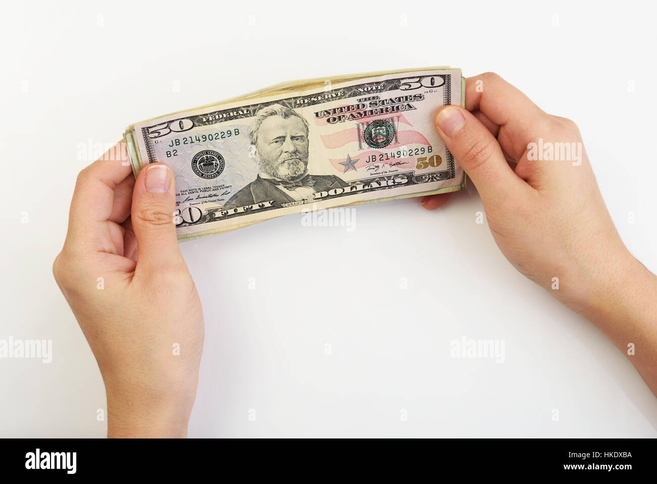 Person, die Dollar in Händen auf weißem Hintergrund Stockfoto