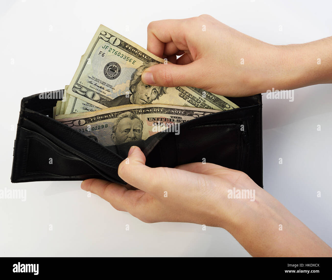Person, die zwanzig Dollar Geld aus schwarzen Brieftasche Stockfoto