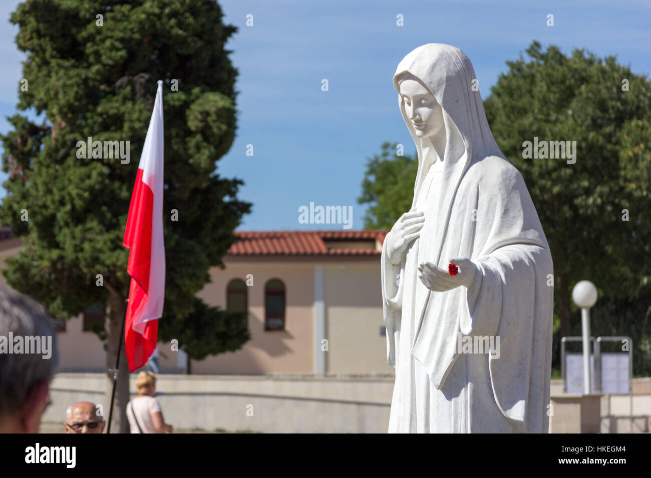 MEDJUGORJE, BOSNIEN UND HERZEGOWINA, 2016/08/20. Die Statue der Jungfrau Maria vor der Kirche des heiligen Jakob. Sie lädt Ihre Kinder zu beten. Stockfoto