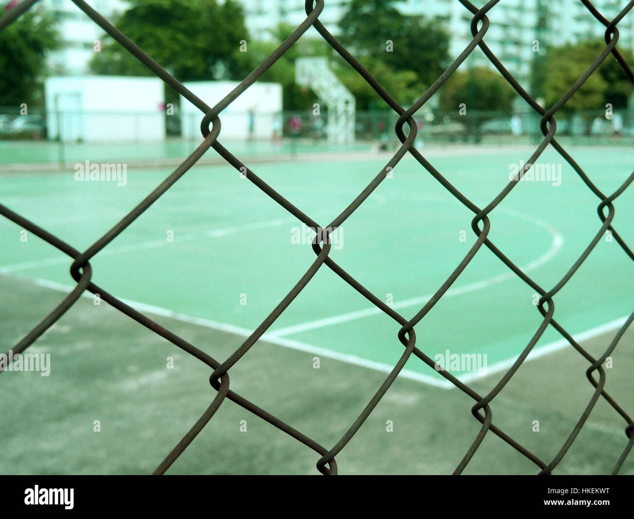 Metal mesh Drahtzaun mit Unschärfe Basketball Court Hintergrund. Stockfoto