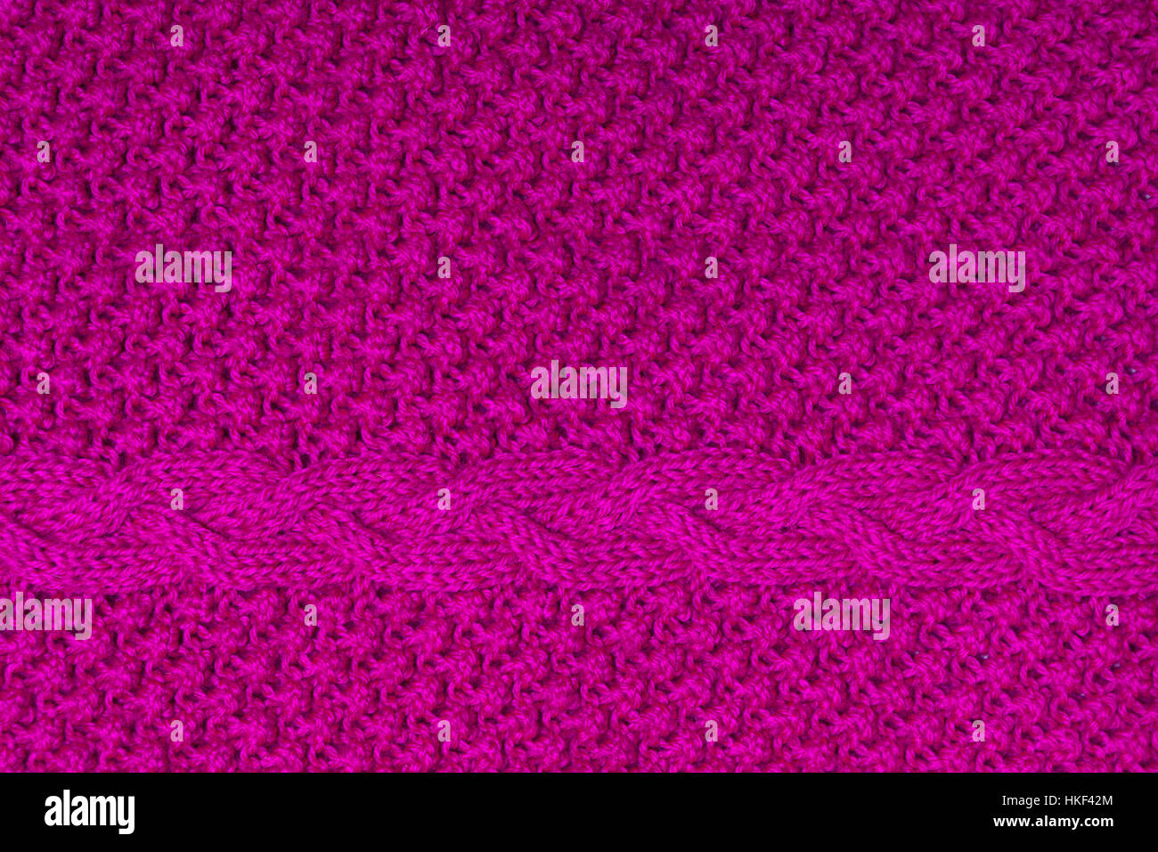 Handgemachte helle Fuchsia gestrickte Textur mit Zopf Stockfoto