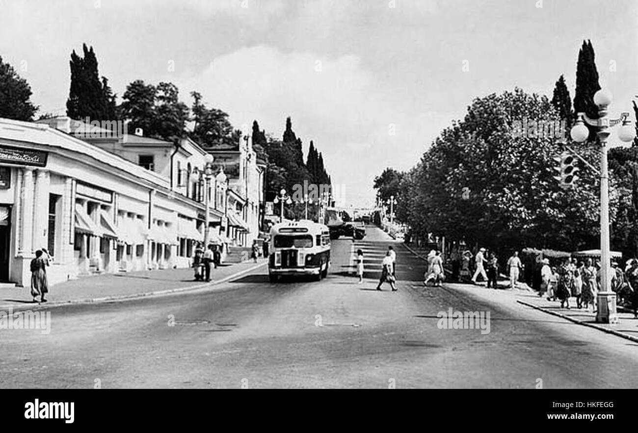 Dieses Gemälde aus den 1930er Jahren zeigt die Stalin Avenue in Sotschi und spiegelt den architektonischen und politischen Einfluss der Zeit in der Sowjetunion wider. Sie hebt die städtische Landschaft dieser Zeit hervor. Stockfoto