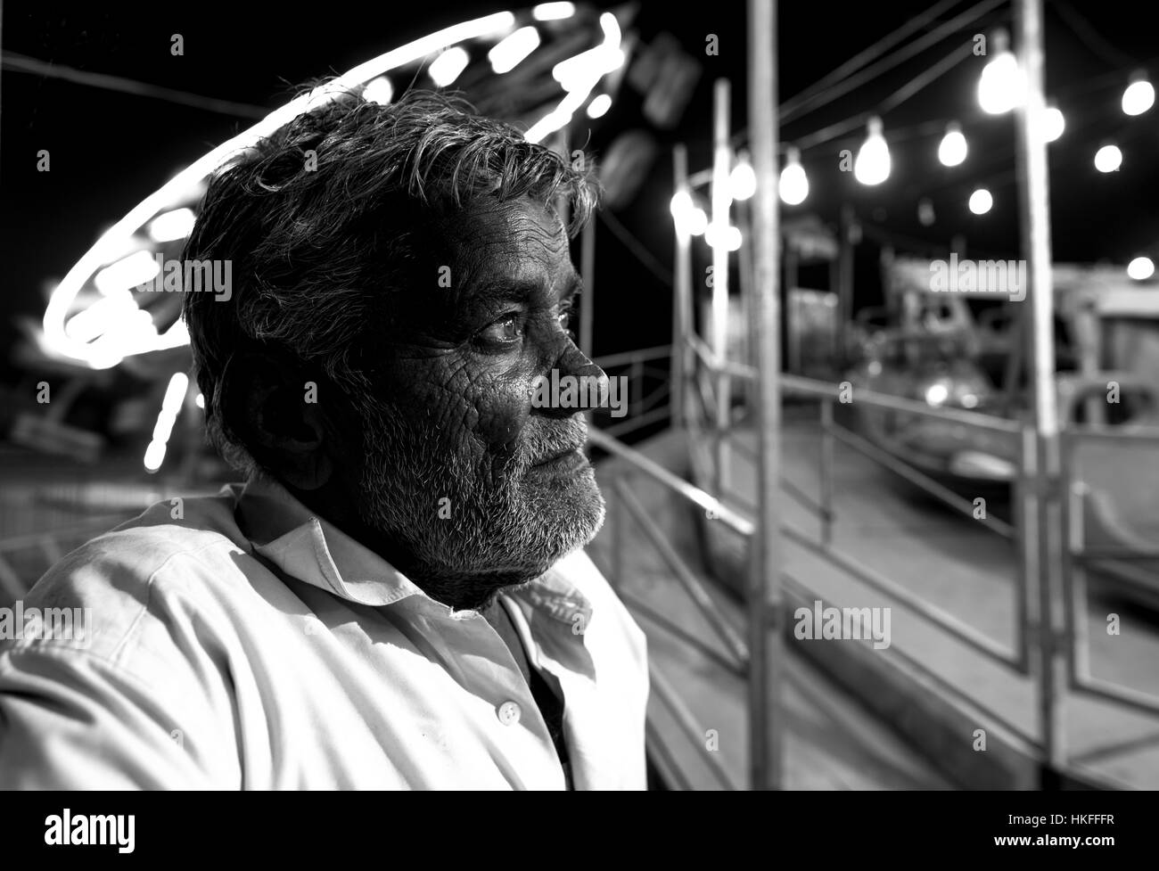 Ein indischer Mann mittleren Alters verloren in Gedanken seine eigenen, Uhren eine Spritztour auf einer Messe. Schwarz / weiß Stockfoto