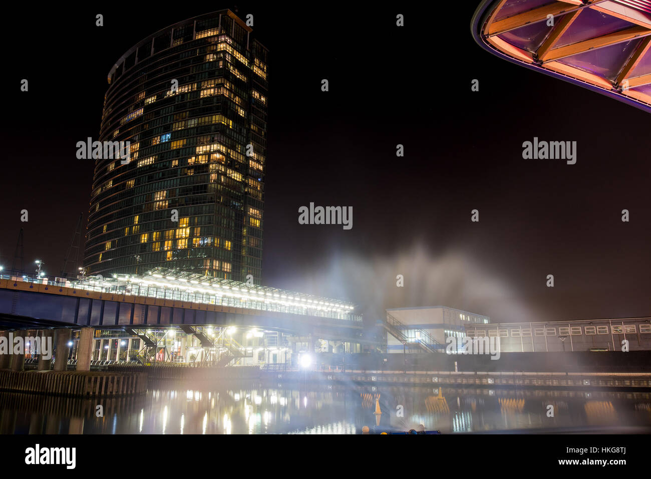 Großer beleuchteter Wolkenkratzer in einer Werft in der Nacht Stockfoto