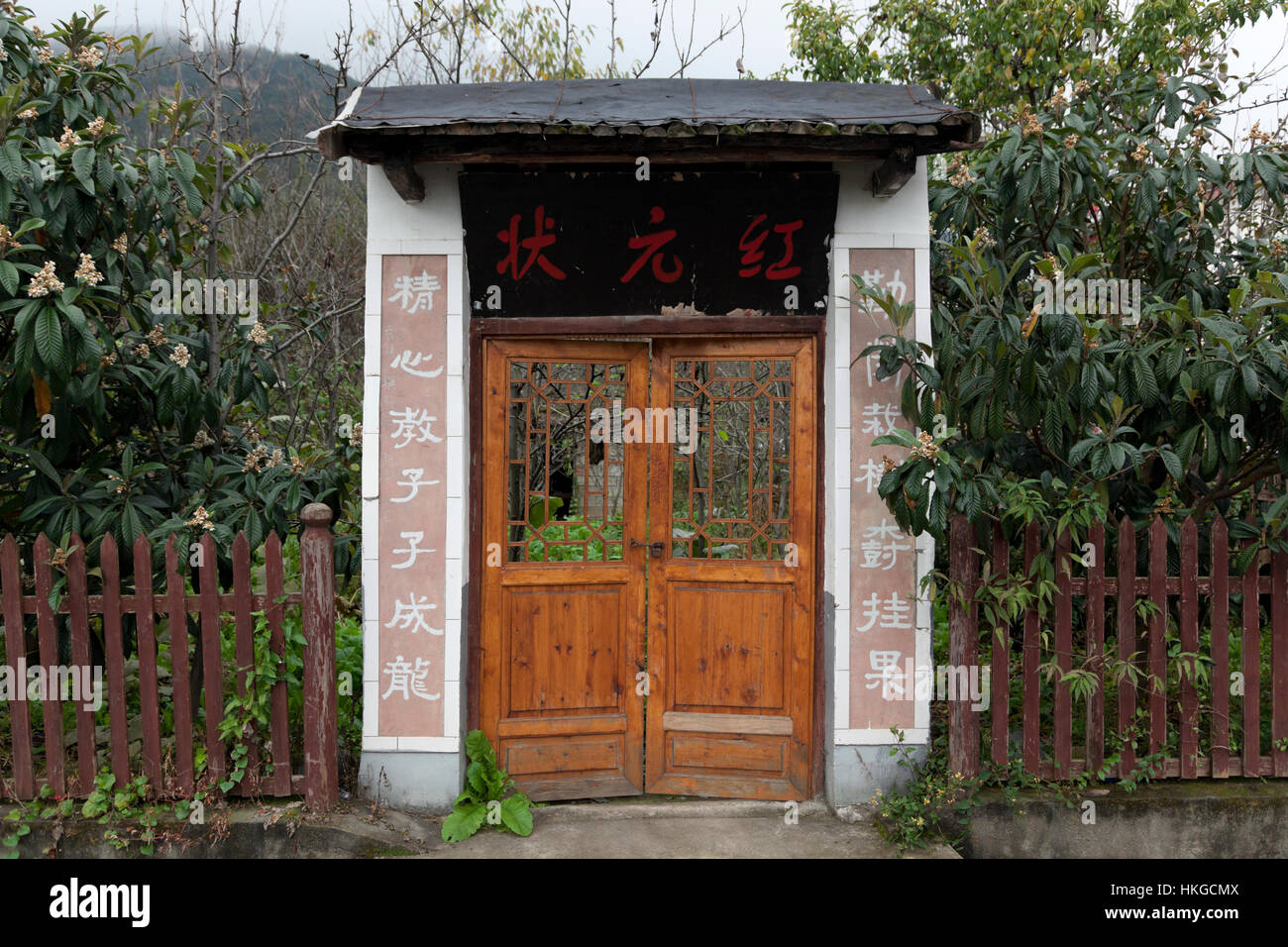 Eine Tür führt zu einem Obstgarten in einer landwirtschaftlichen Dorf in China. Stockfoto