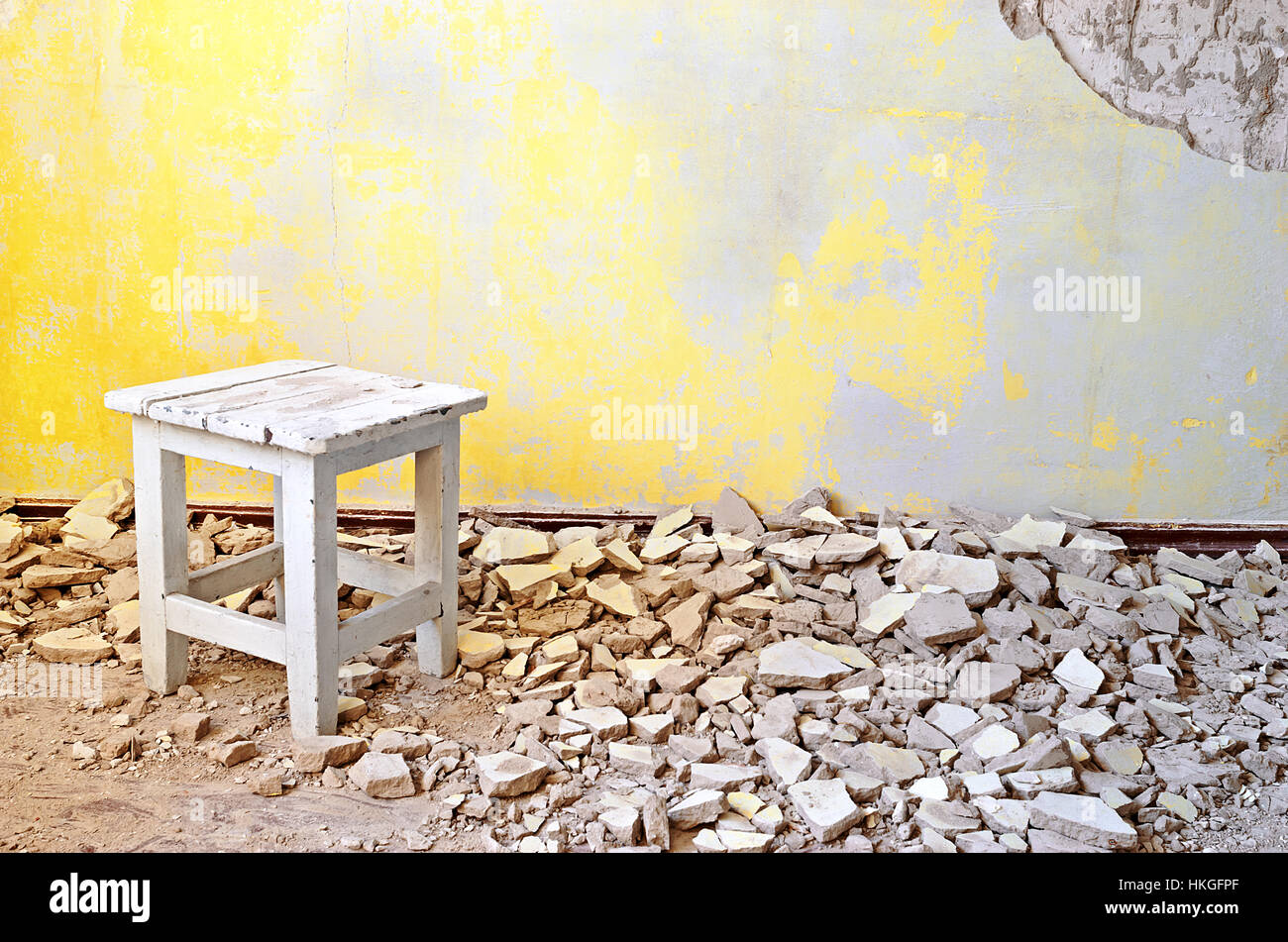 Alte Vintage Holzstuhl in einem verlassenen Grunge-Raum mit gerissenen gelbe Zement Mörtel Wand Hintergrund. Grunge Vintage Interieur. Stockfoto