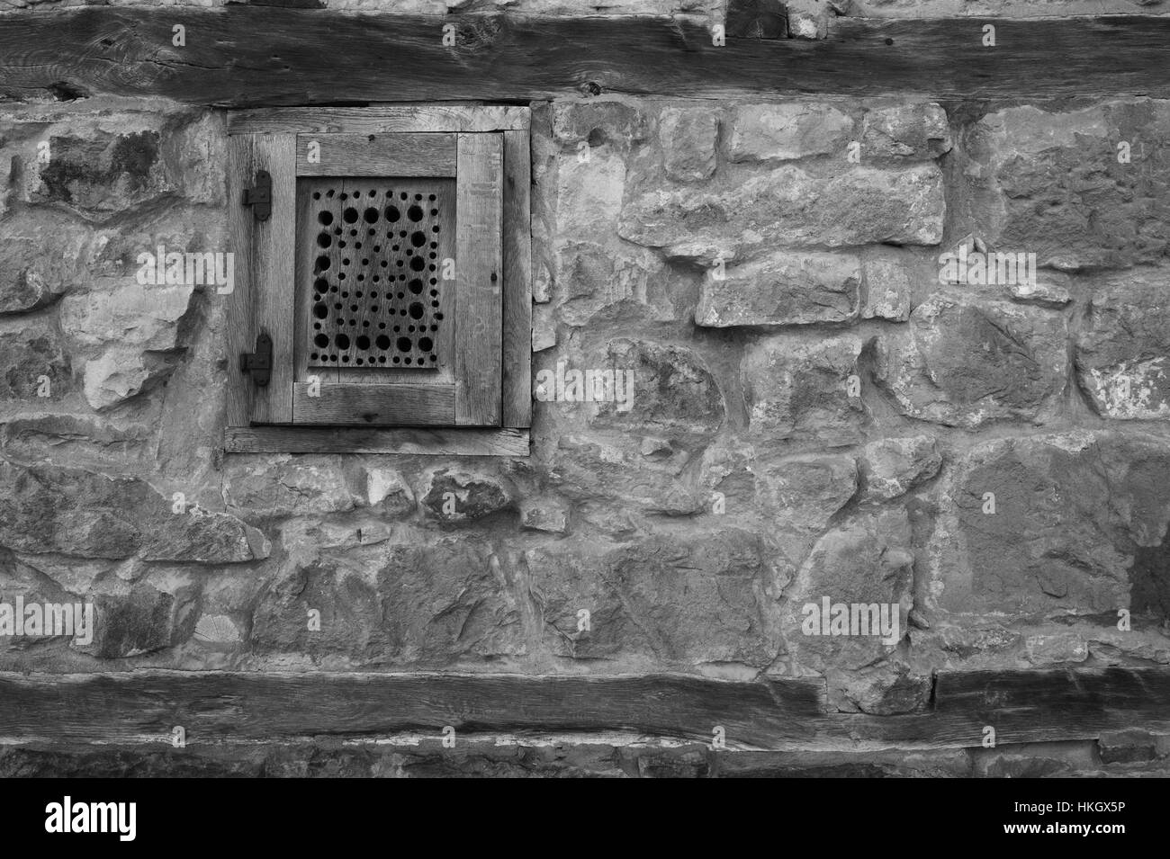 Holzfenster an Steinwand in schwarz / weiß Stockfoto