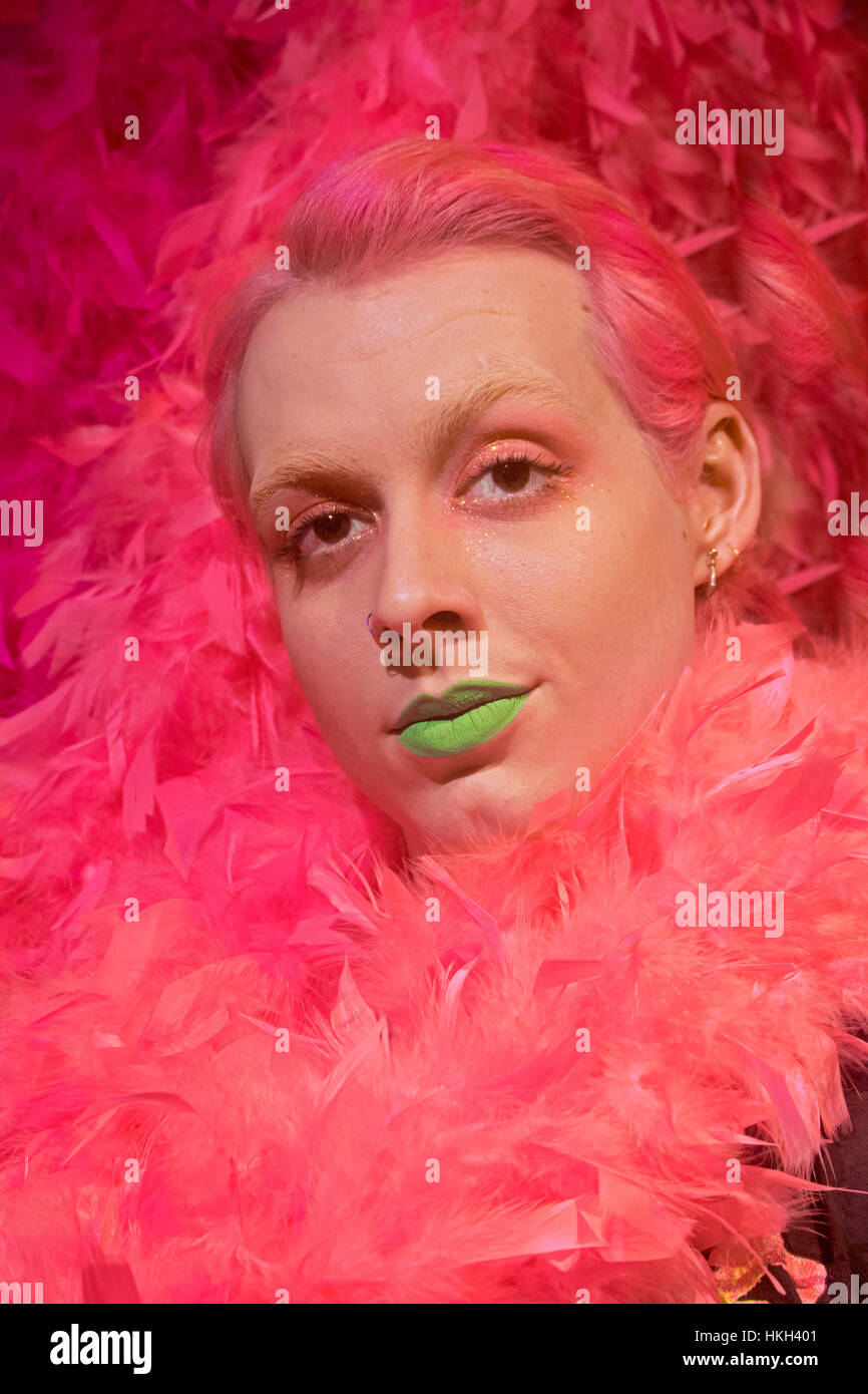 Stellen Porträt einer Übergang transgender junge Frau mit rosa Haaren, rosa und grünen Augen Make-up Lippenstift. In Downtown Manhattan, New York City Stockfoto