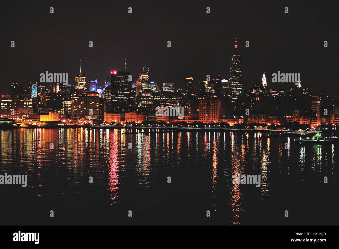 Manhattan Wolkenkratzer Lichter spiegeln sich im Wasser in der Nacht Stockfoto