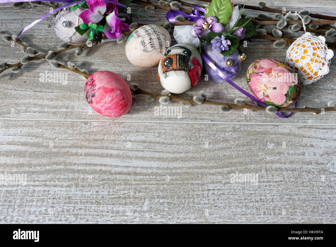 Serviettentechnik dekoriert bunte Ostereier mit Weidenzweigen auf Holztisch Stockfoto