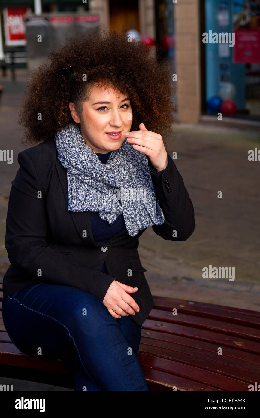 Französisch-algerischen Studentin sitzt an einem kalten Tag in Dundee City Centre, Schottland, UK Stockfoto