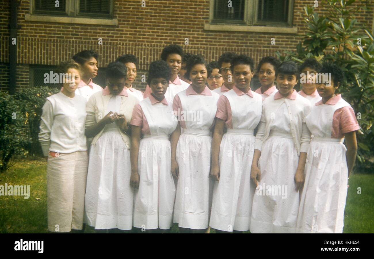 Abschluss Klasse von Krankenschwestern im Grady Memorial Hospital in Atlanta, Georgia, in erster Linie afro-amerikanische Frauen stehen und zu posieren für ein Gruppenfoto tragen weiße Krankenschwester Kleider mit rosa Unterhemden auf einer Wiese vor dem Backsteingebäude des Krankenhauses, Juni 1957. Stockfoto