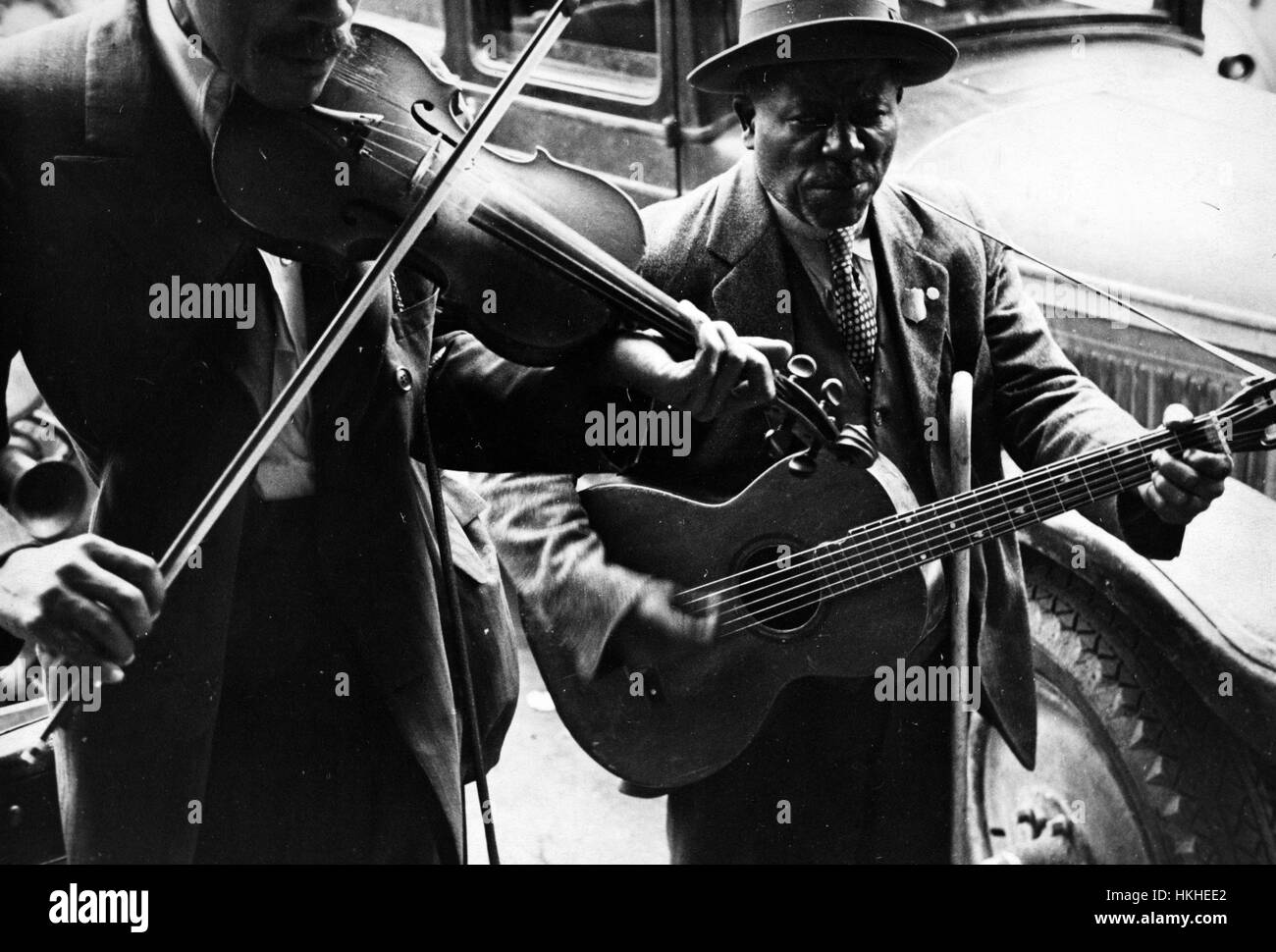 Schwarz / weiß Foto zwei afro-amerikanische Männer, Straßenmusikanten, eine Geige, die andere eine Gitarre von Walker Evans, US-amerikanischer Fotograf am besten bekannt für seine Arbeit für die Farm Security Administration dokumentieren die Auswirkungen der Weltwirtschaftskrise, Westmemphis, Arkansas, 1935. Von der New York Public Library. Stockfoto