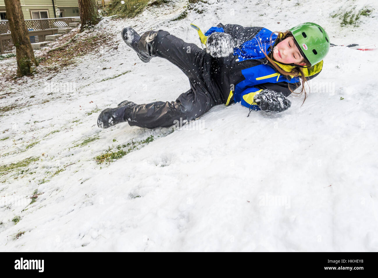 Junge übt Snowboarden im Schnee im Hinterhof, Stockfoto