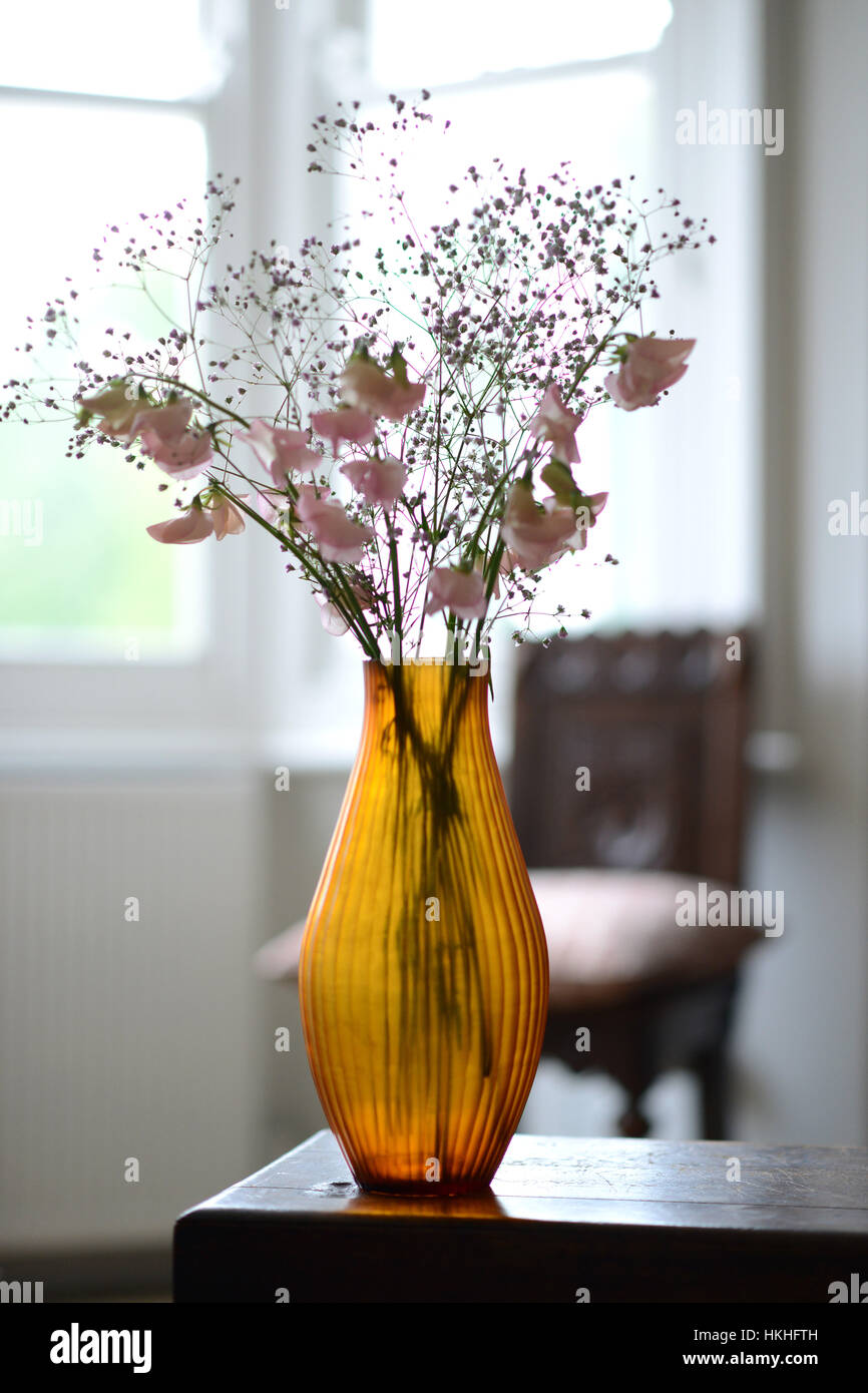 Braunglas geriffelte Vase mit Blumen in einem Raum Stockfoto