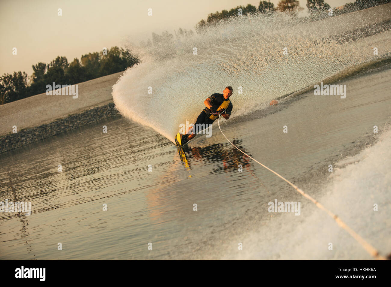 Wakeboarder Surfen über den See hinter Motorboot. Mann-Wasserski auf See mit Wasser spritzt. Stockfoto