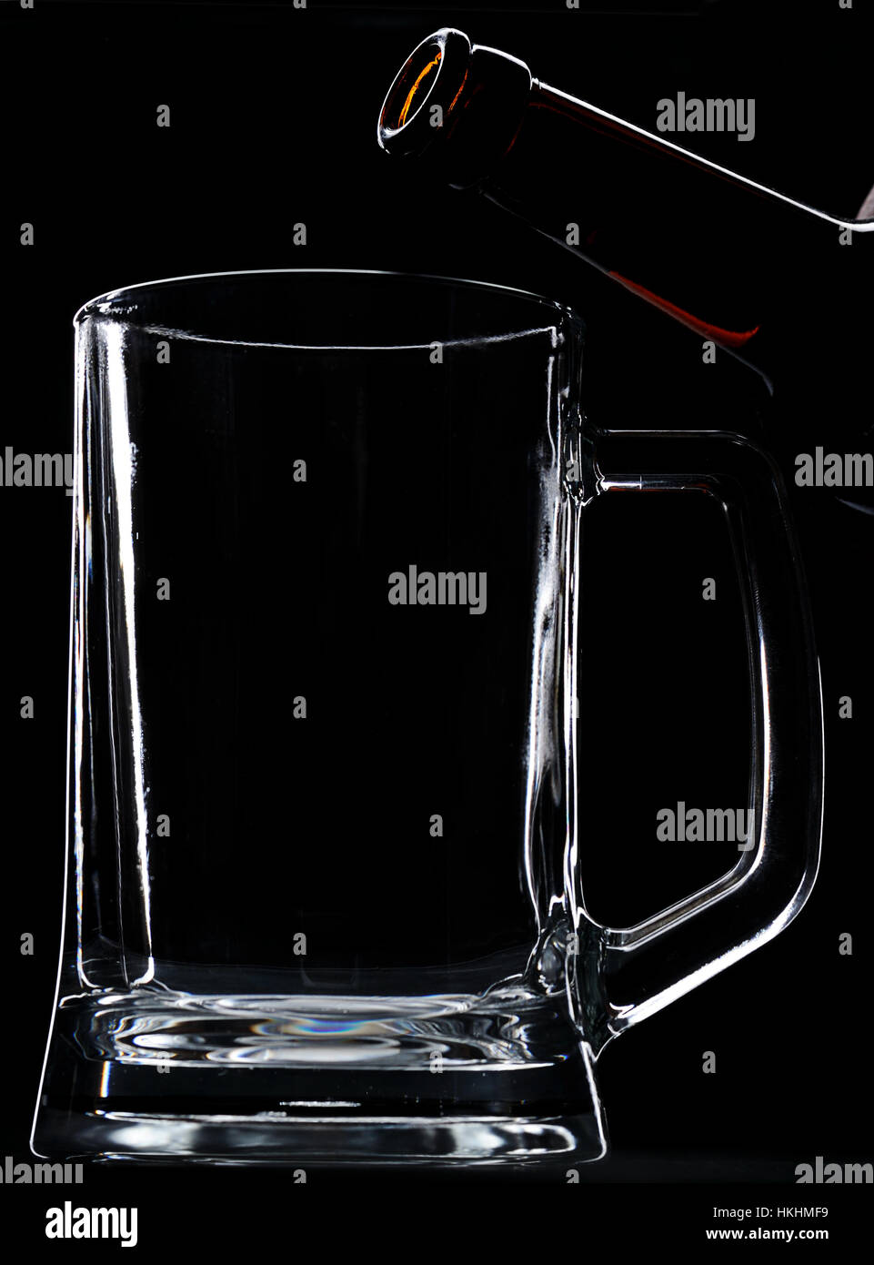 Flasche auf bereit zum Bier zu leeren Glas auf schwarzem Hintergrund setzen Stockfoto