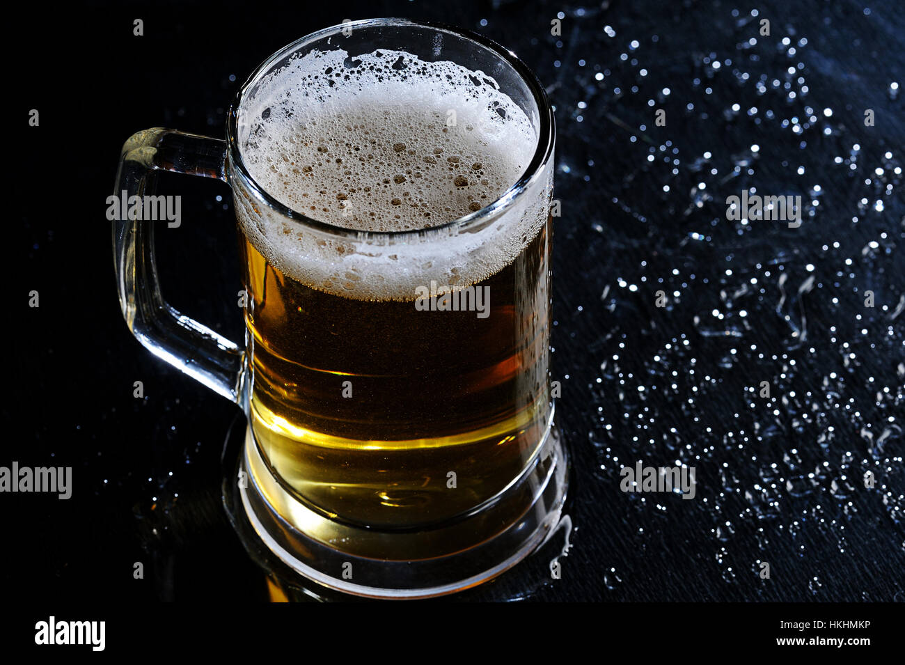 Braun Glas Bier auf schwarzen nassen Glanz Tisch Stockfoto