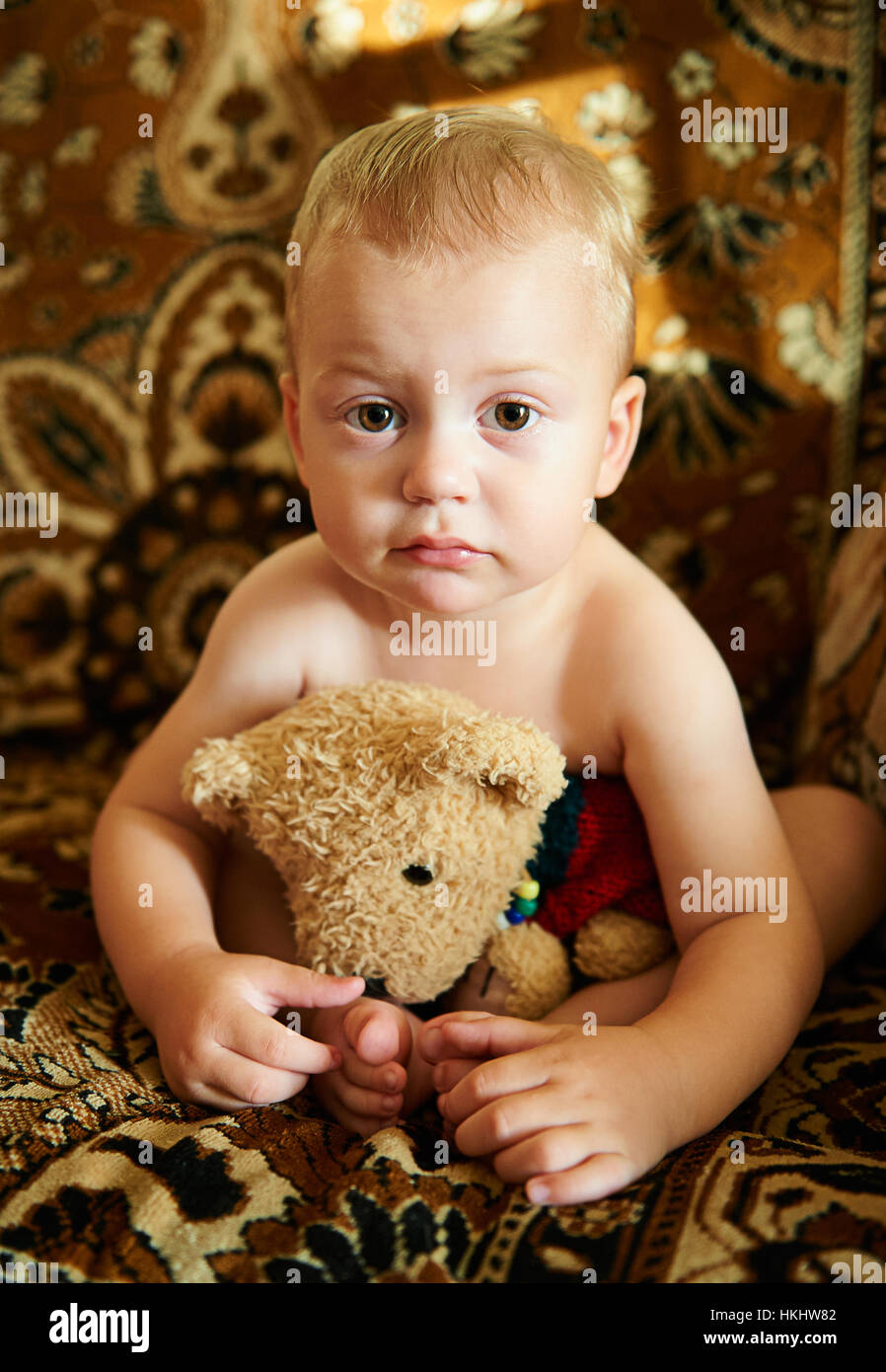 kleiner Junge mit Teddy bear kein Hemd in Wohnung Stockfoto