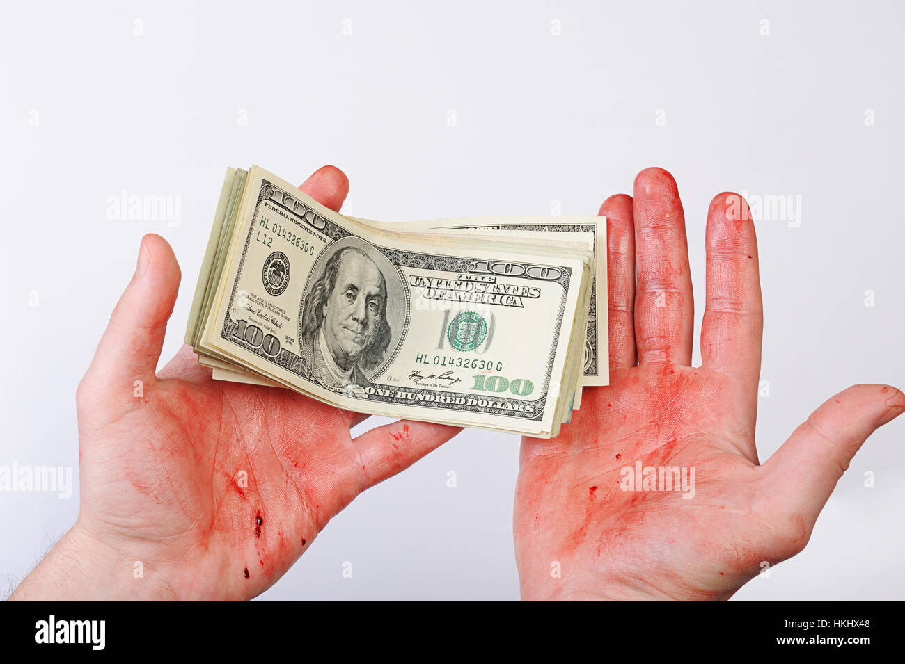 Dollar auf blutigen Händen auf weißem Hintergrund Stockfoto