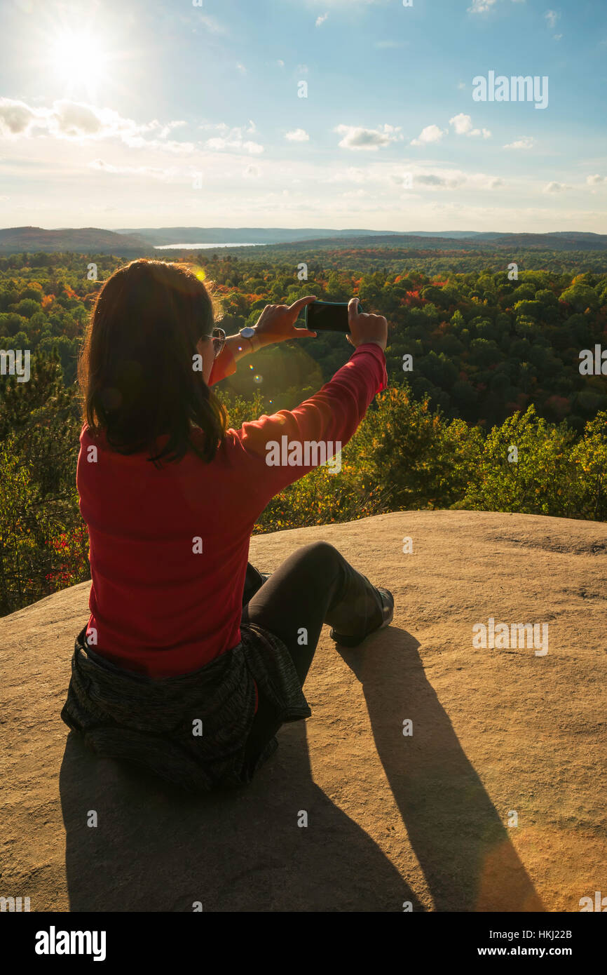 Frau, die das Fotografieren mit einem Smartphone in Algonquin Park; Ontario, Kanada Stockfoto