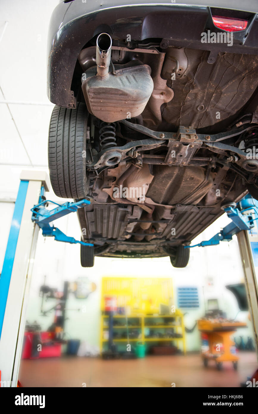 Von unten Blick auf Auto unten hob bei Autowerkstatt über innere Hintergrund Unschärfe. Textfreiraum Stockfoto