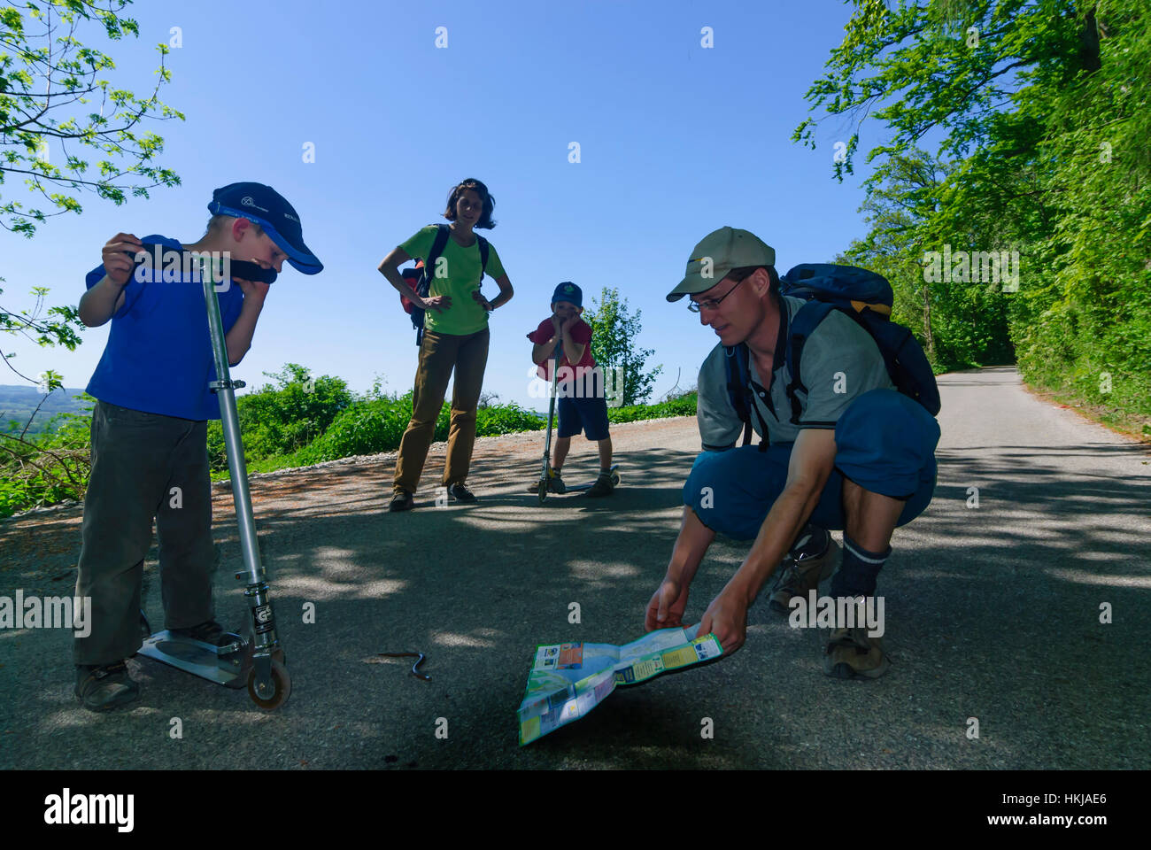 : Familie zeigt den Weg nach Hause zu einem Blindworm mit Hilfe einer Karte, Oberbayern, Oberbayern, Bayern, Bayern, Deutschland Stockfoto