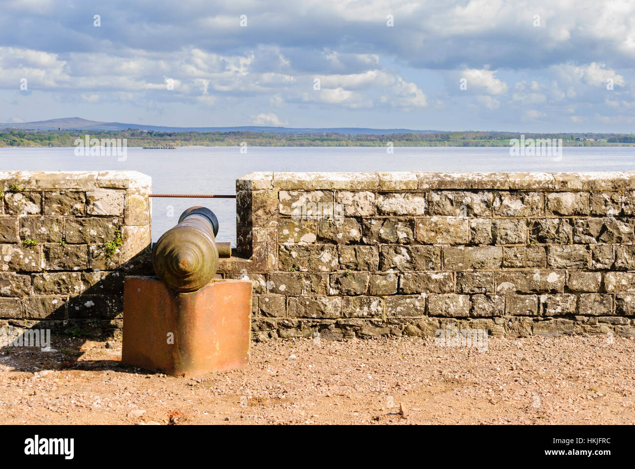 Kanone auf einer Burgmauer mit Blick auf eine schmale Meer. Stockfoto