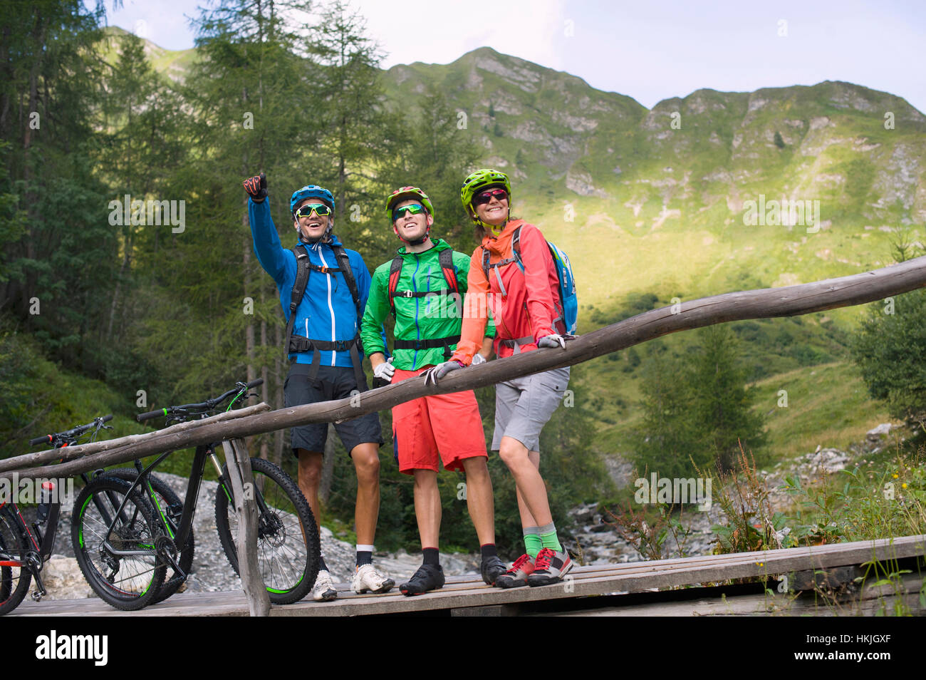 Drei Mountain-Biker-Freunde stehen auf Steg und zeigt etwas zu seinen Freunden, Zillertal, Tirol, Österreich Stockfoto