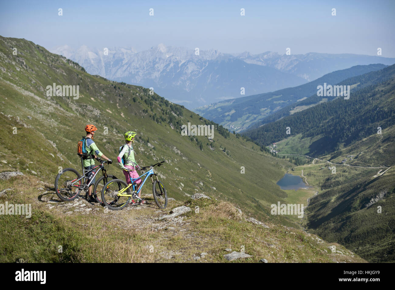 Junges Paar Mountainbiker betrachten in alpiner Landschaft, Zillertal, Tirol, Österreich Stockfoto