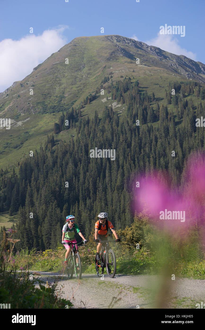 Zwei Mountainbiker fahren auf unbefestigten Straße durch Wald, Zillertal, Tirol, Österreich Stockfoto
