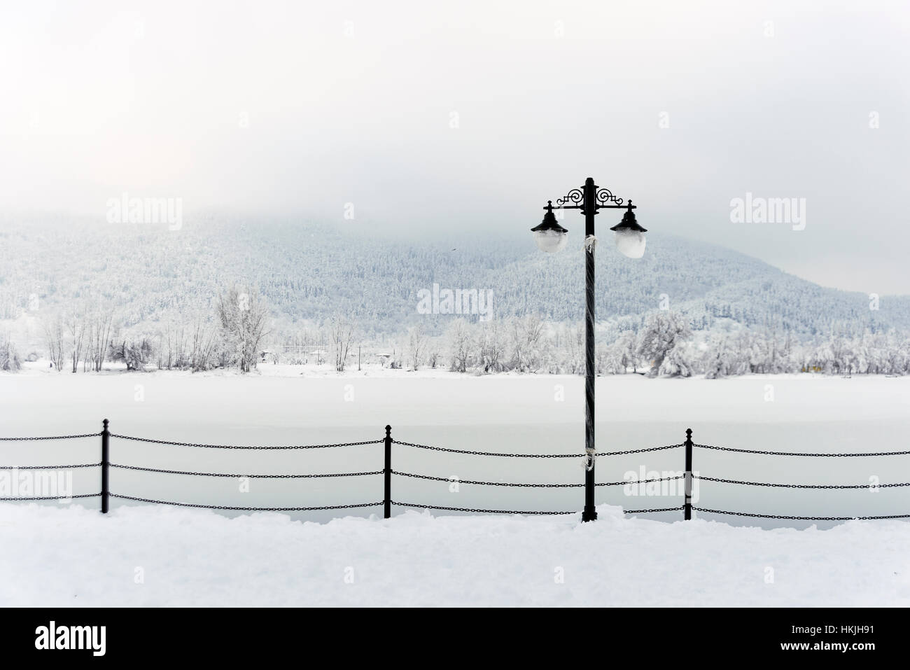 Alte Mode Straßenlaterne Schnee und einem zugefrorenen See im Hintergrund. Stockfoto
