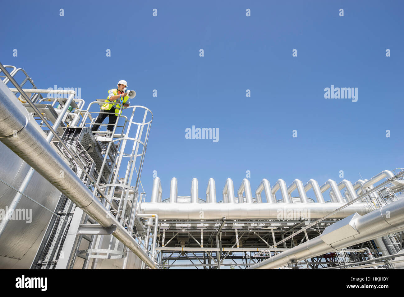 Niedrigen Winkel Ansicht eines Ingenieurs mit einem Megaphon auf geothermische Kraftwerk, Bayern, Deutschland Stockfoto