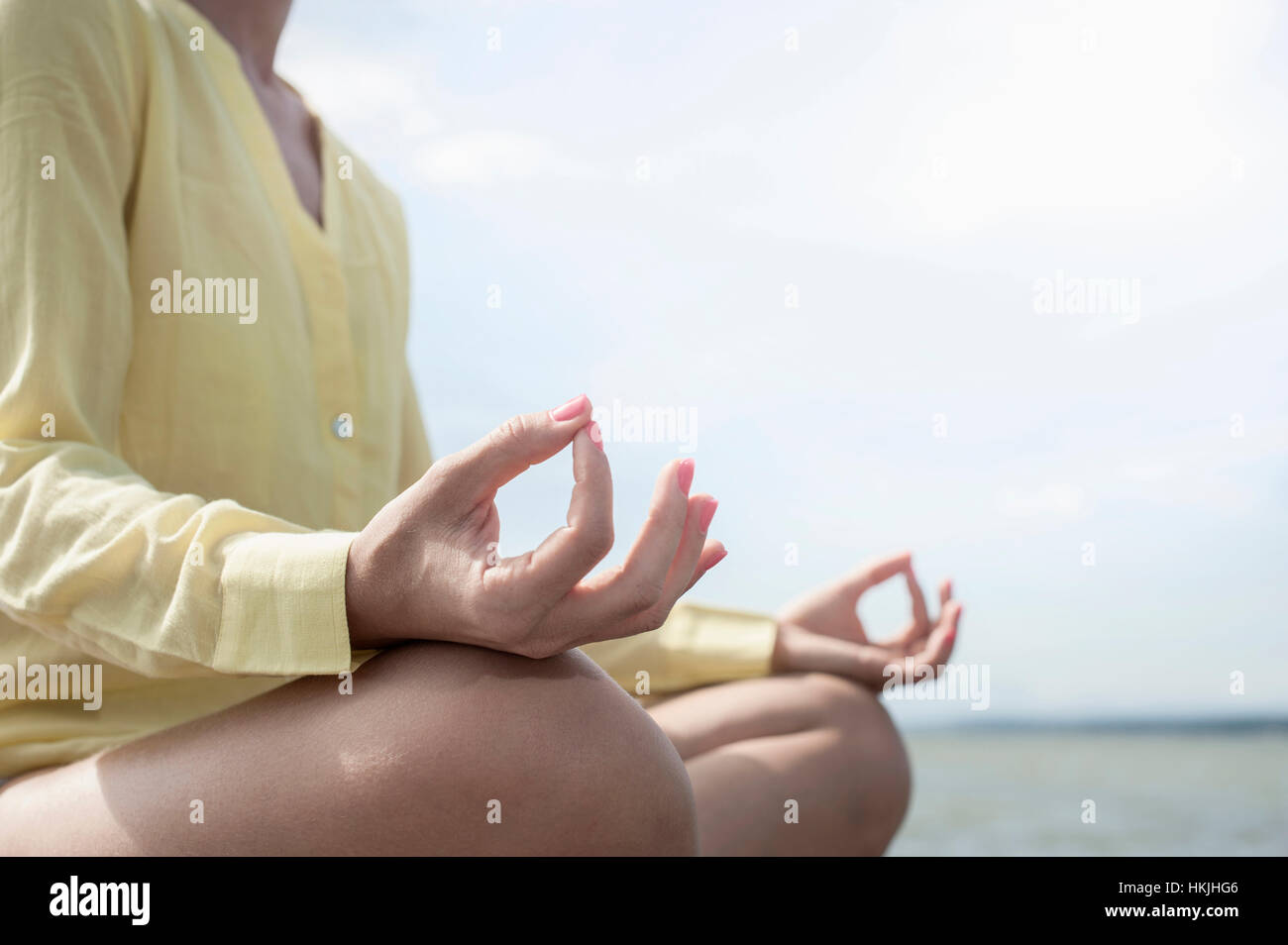 Mittleren Bereich einer Frau beim Lotus Pose Yoga am See, Ammersee, Oberbayern, Deutschland Stockfoto