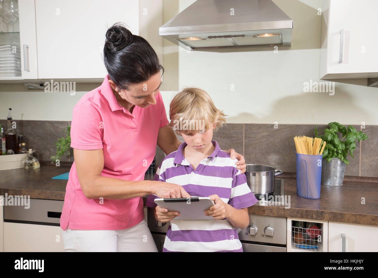 Frau mit ihrem Sohn mit digital-Tablette in Küche, Bayern, Deutschland Stockfoto