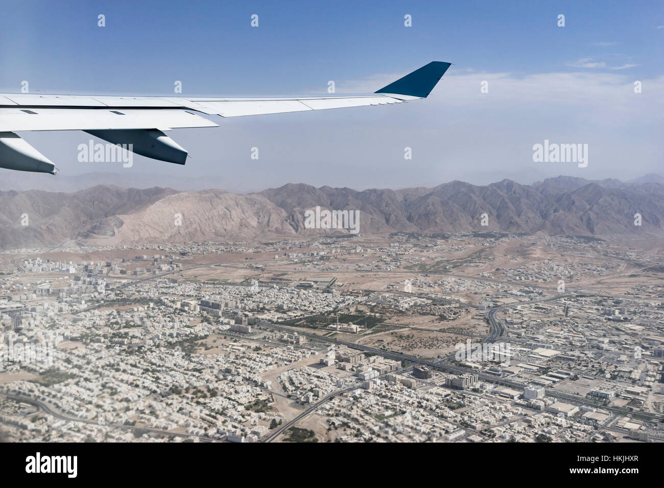 Abgeschnitten Bild Flugzeug fliegen über Stadt, Maskat, Oman Stockfoto