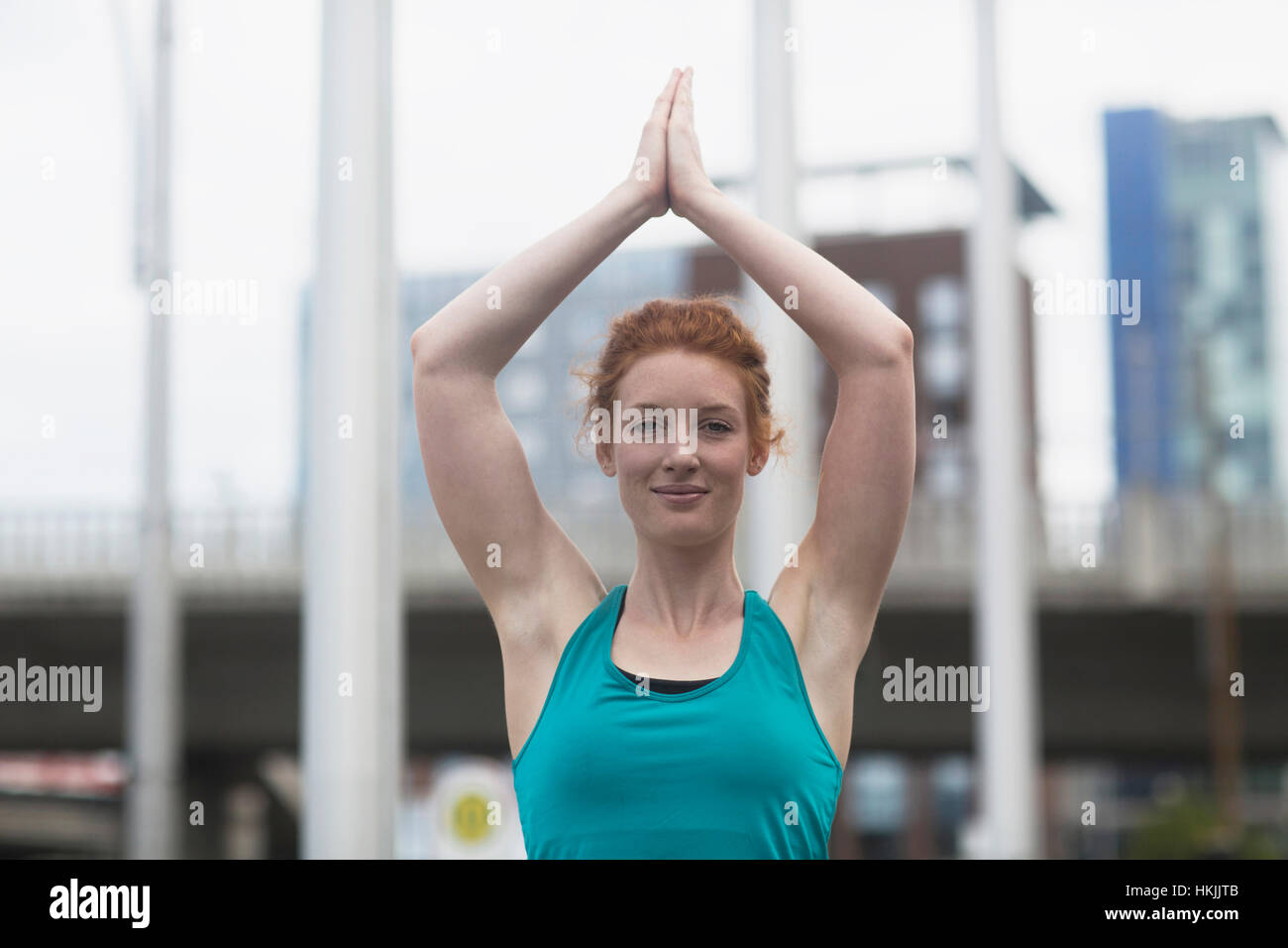 Porträt einer jungen Frau, die beim Lotus Pose Yoga in Großstadt, Freiburg Im Breisgau, Baden-Württemberg, Deutschland Stockfoto