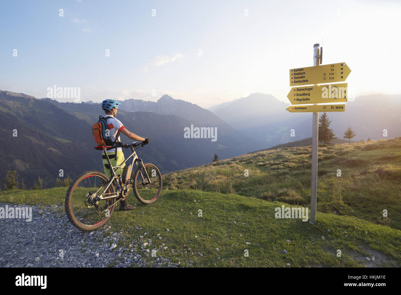 Rückansicht der Mountainbiker in die alpine Landschaft stehen und betrachten während Sonnenuntergang, Zillertal, Tirol, Österreich Stockfoto