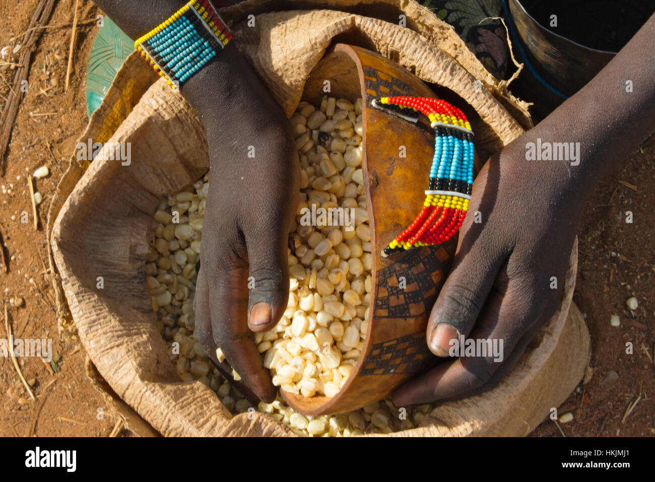 Ari Stamm Menschen scooping Maiskörner am Markt, Jinka, South Omo, Äthiopien Stockfoto