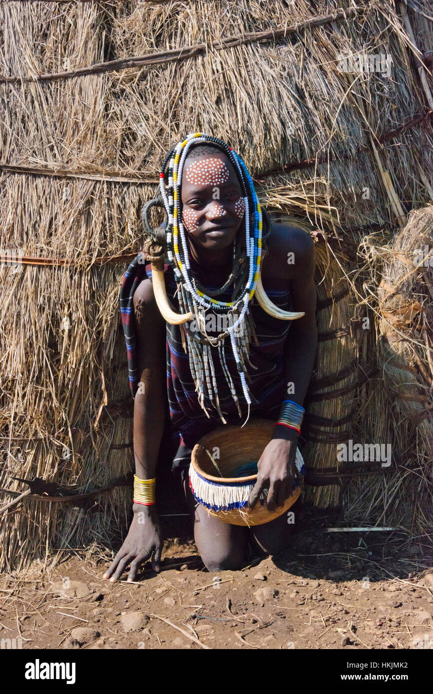 Mursi Stamm Menschen in traditioneller Kleidung vor traditionellen Haus aus Stroh, Mursi Dorf, Süd-Omo, Äthiopien Stockfoto