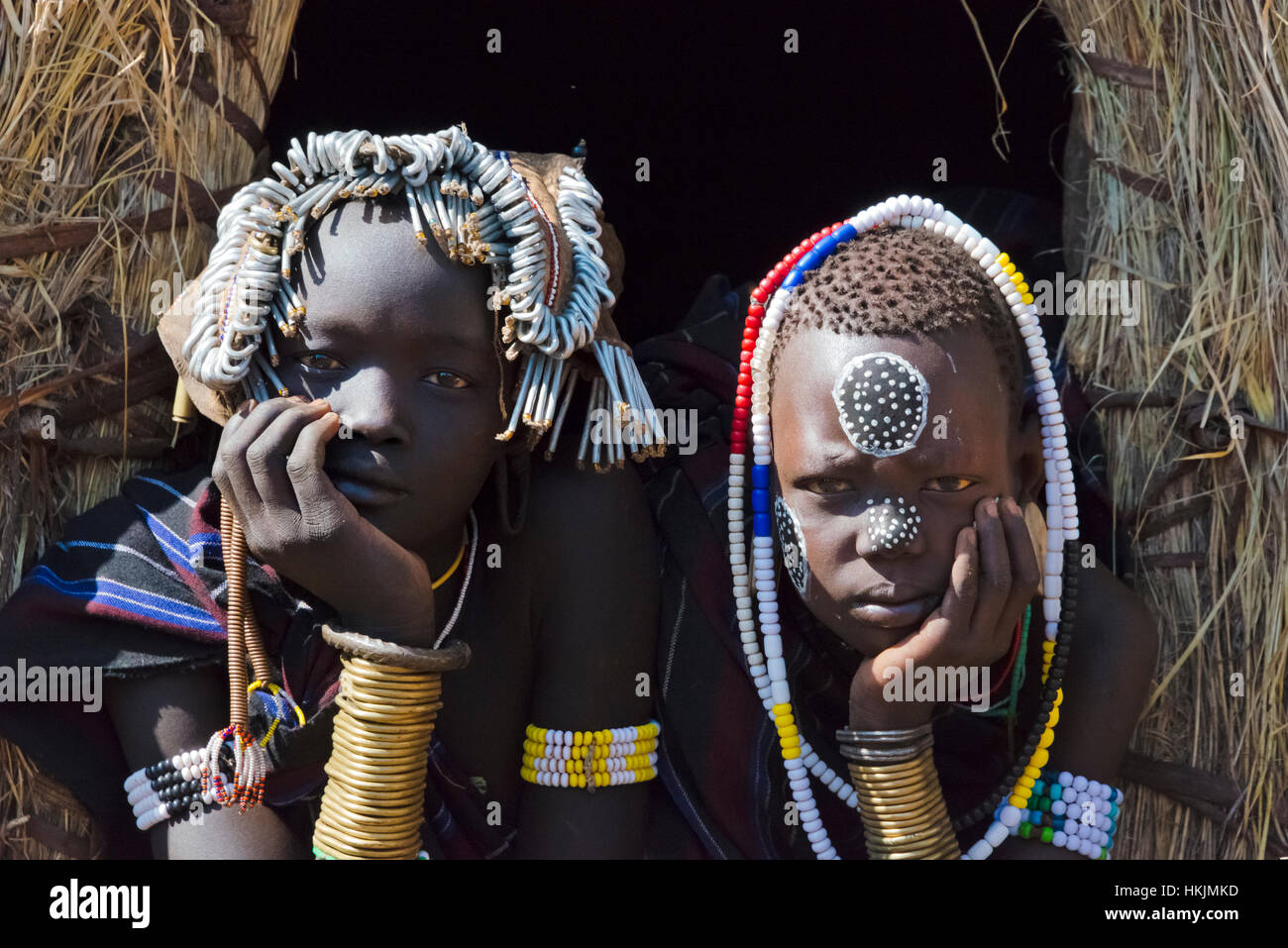 Mursi Stamm Menschen in traditioneller Kleidung vor traditionellen Haus aus Stroh, Mursi Dorf, Süd-Omo, Äthiopien Stockfoto