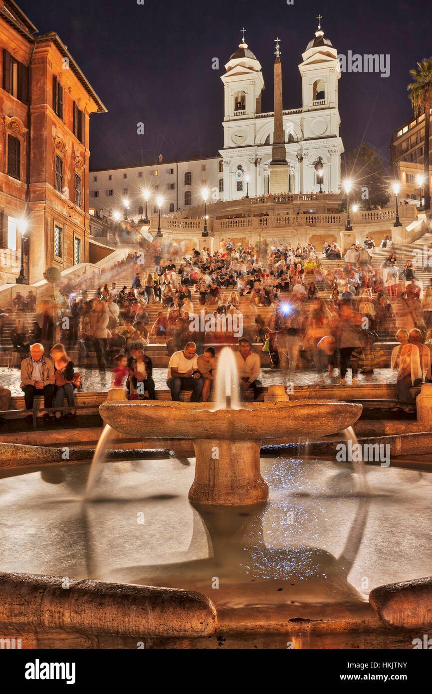 Touristen sitzen auf der spanischen Treppe an Brunnen, Piazza di Spagna, Rom, Italien Stockfoto
