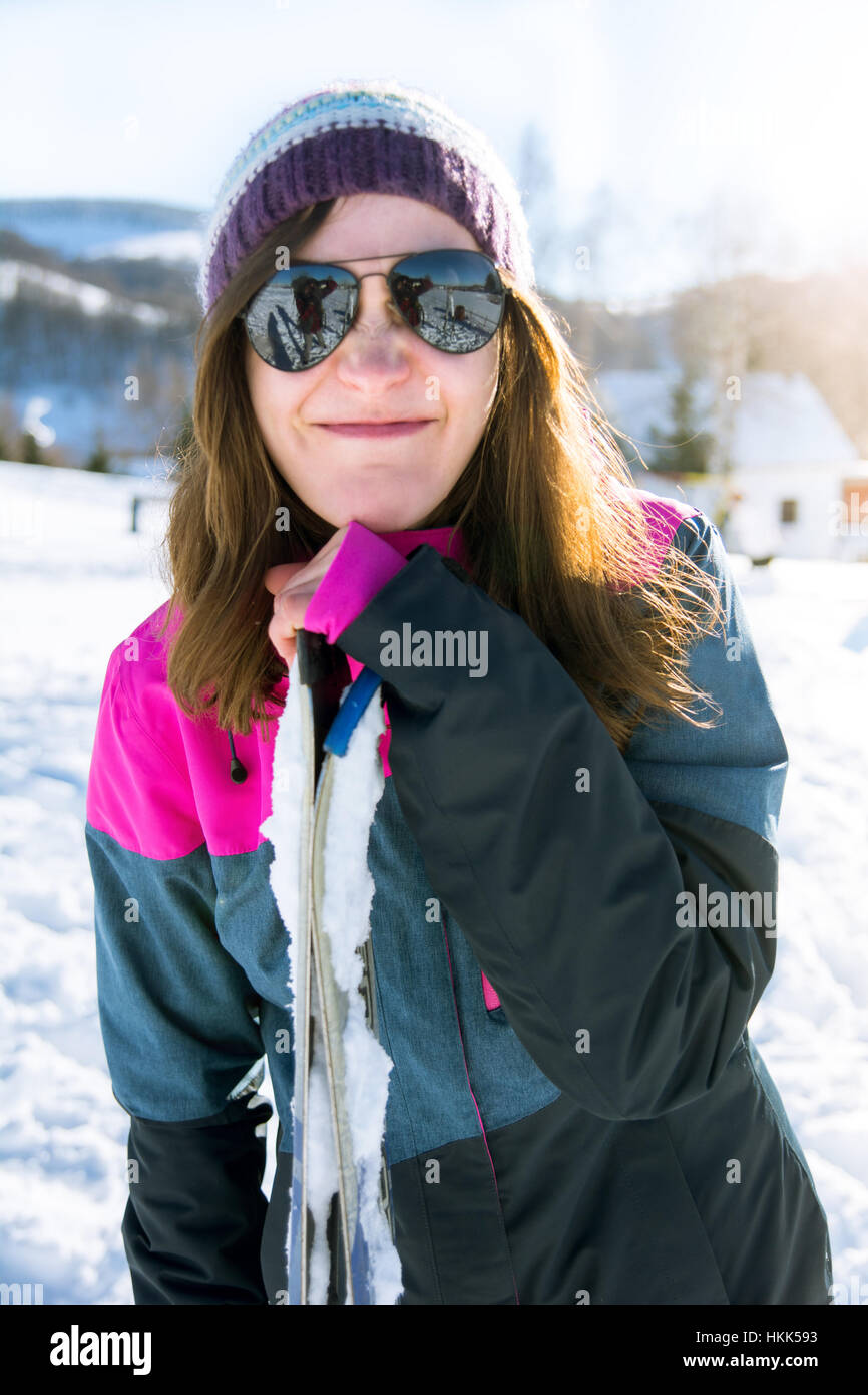 Mädchen machen ein lustiges Gesicht, stützte sich auf Skiern im freien Stockfoto