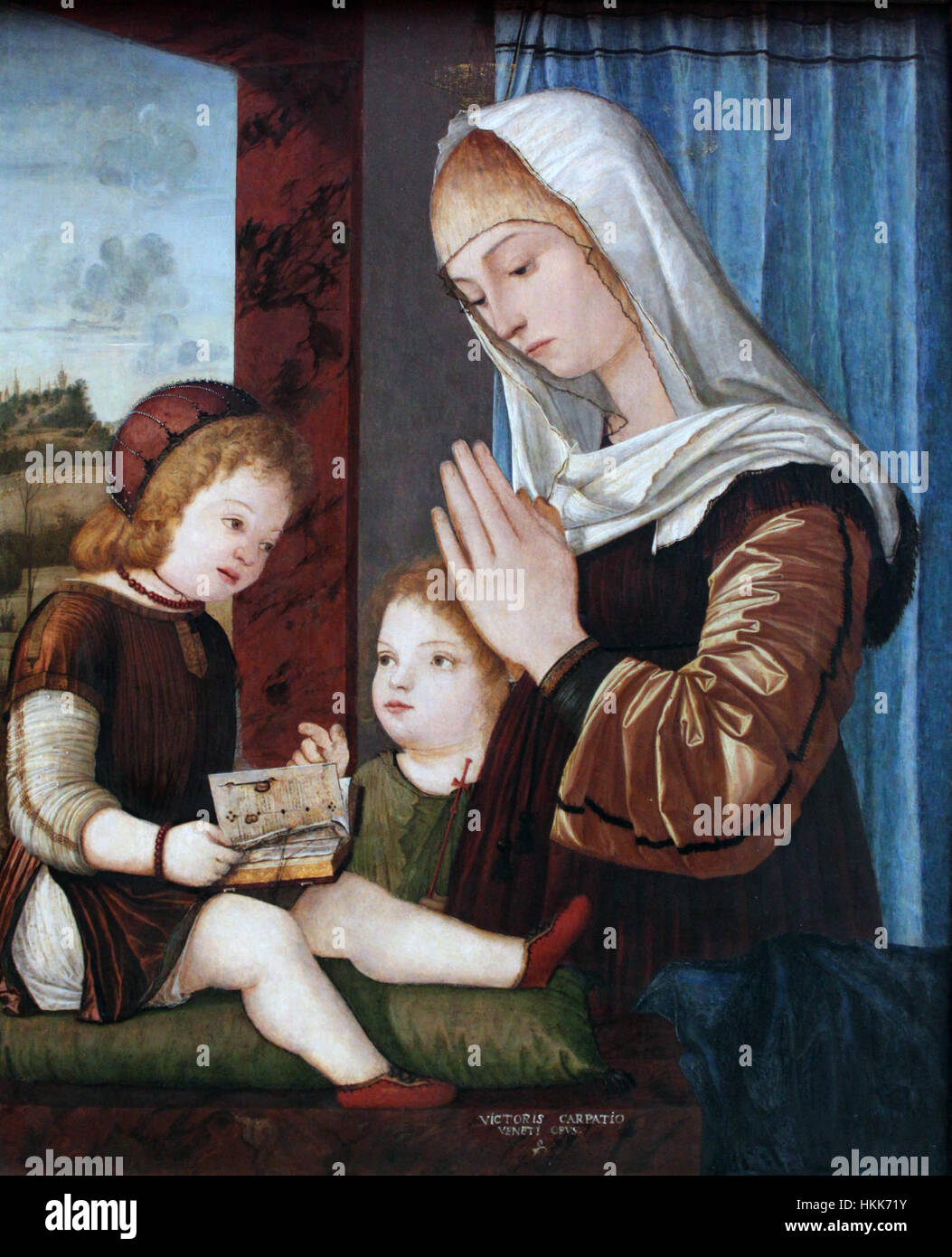 Dieses Gemälde von Carpaccio aus dem Jahr 1499 zeigt die Madonna mit Kind und das Kind Johannes den Täufer. Das Werk ist ein gutes Beispiel für religiöse Kunst der frühen Renaissance, mit lebendigen Farben und detaillierten Figuren. Stockfoto