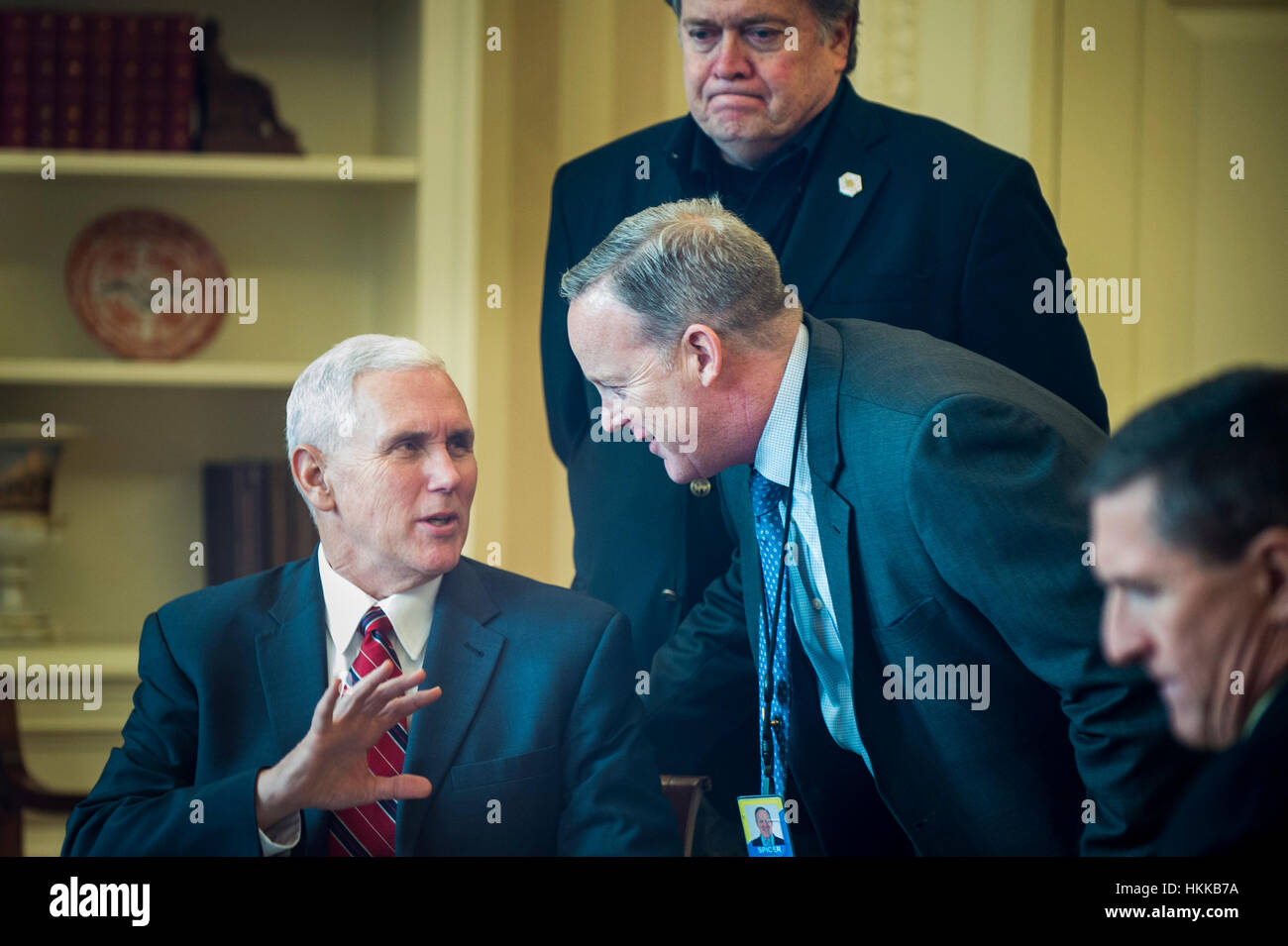 Washington DC, USA. 28. Januar 2017. US-Vize-Präsident Mike Pence spricht mit White House Pressesprecher Sean Spicer als Präsident Donald Trump mit Präsident von Rußland Vladimir Putin am Telefon im Oval Office in Washington, DC spricht. Der Aufruf war einer der fünf Gespräche mit ausländischen Führern für Samstag geplant. Chief Strategist Stephen K. Bannon und National Security Advisor Michael Flynn waren auch im Zimmer. Bildnachweis: MediaPunch Inc/Alamy Live-Nachrichten Stockfoto